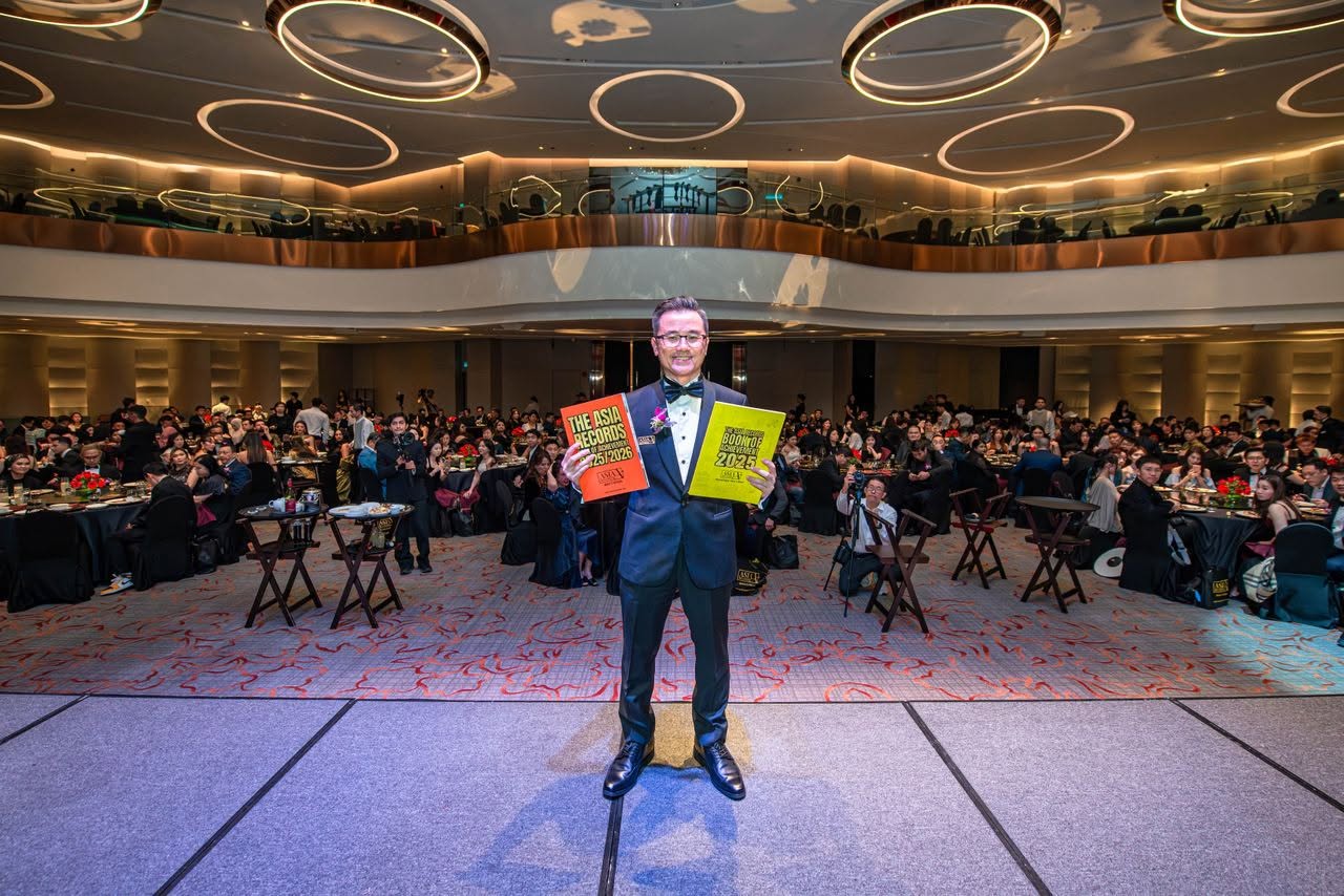 Dato KK Chua on stage with asia record book of achievement